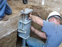 Foundation repair contractors installing the foundation bracket in Huntsville.
