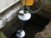 Installing a helical pier system in the earth around a foundation in Montgomery