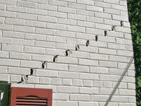 Stair-step cracks showing in a home foundation in Cullman