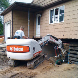 Excavating to expose the foundation walls and footings for a replacement job in Bessemer